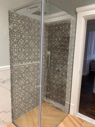 um chuveiro de vidro num quarto com uma parede em Royal apartament em Durrës