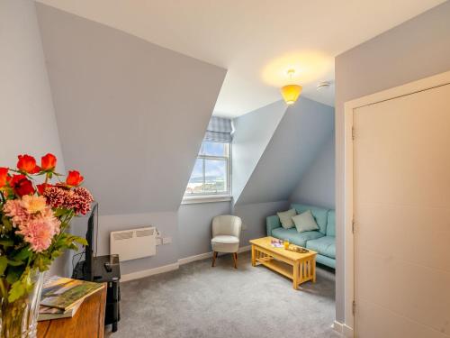 a living room with a blue couch and a table at Bay View - Uk38589 in Inverkeithing