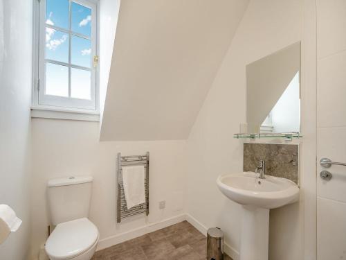 a white bathroom with a toilet and a sink at Bay View - Uk38589 in Inverkeithing