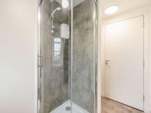 um chuveiro com uma porta de vidro na casa de banho em Inverkeithing View - Uk38588 em Inverkeithing