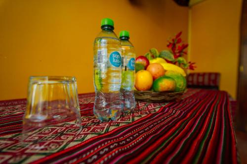 a table with two bottles and a basket of fruit at Yacumama Santa Teresa in Santa Teresa