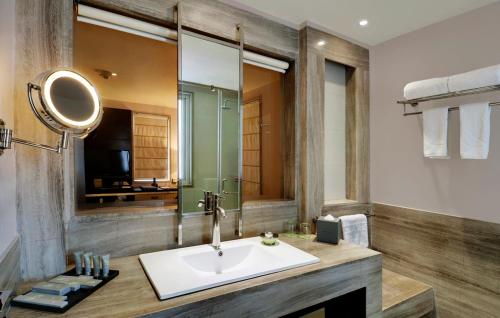 a bathroom with a sink and a mirror at Quality Inn Gurgaon in Gurgaon