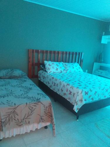 two beds in a bedroom with blue walls at Hostel e Pousada Maria Bonita in Paripueira