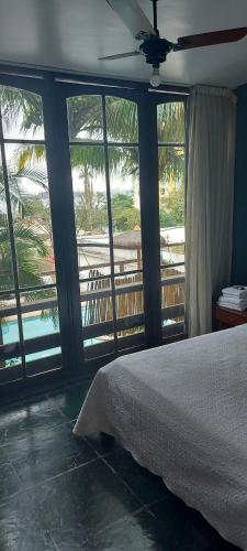 a bedroom with a bed and a view of a balcony at Pousada Charitas Saint Malo in Niterói