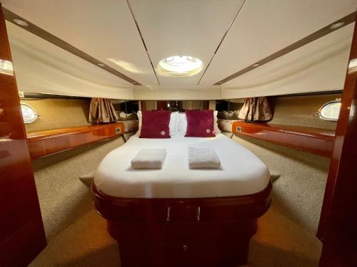 een bed in het midden van een kleine kamer bij Tranquility Yachts -a 52ft Motor Yacht with waterfront views over Plymouth. in Plymouth