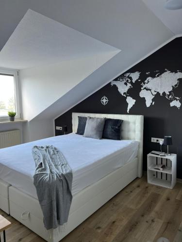 a bedroom with a large white bed with a black wall at Schicke Wohnungen in Stadtnähe in Würzburg