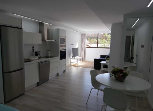 cocina y sala de estar con mesa y sillas. en Apartamento Nuevo en Playa del Águila Maspalomas, en San Bartolomé