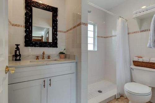 een badkamer met een wastafel, een toilet en een spiegel bij Lovely 2 bedroom condo in the heart of Flagler in Flagler Beach