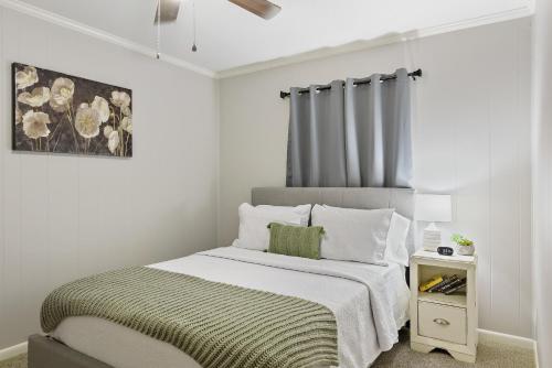 a white bedroom with a bed and a night stand at Unit 19 Green Acres Apartment in Enterprise