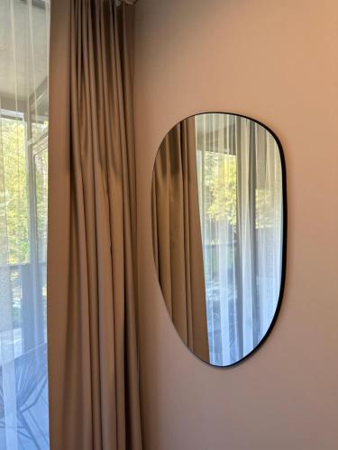 a mirror hanging on a wall next to a window at Naujai įrengti pušyno apartamentai - bekontaktis įėjimas in Birštonas