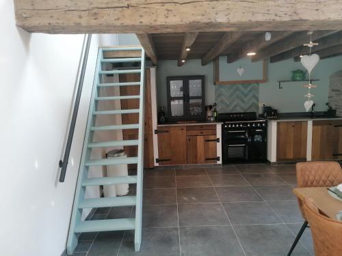 a kitchen with a ladder in the middle of a kitchen at La Maison de Madeleine in Léglise
