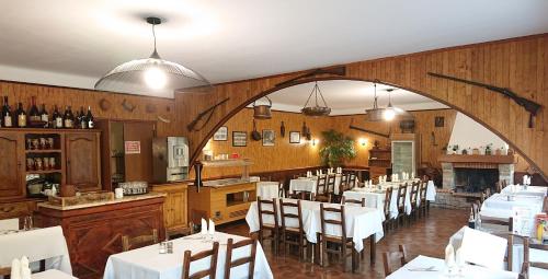 una sala da pranzo con tavoli bianchi e sedie bianche di Scopa Rossa a Evisa