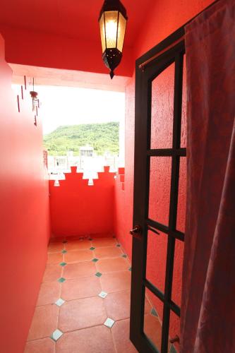 an empty room with a door and a red wall at A Fei Surf Inn III in Nanwan