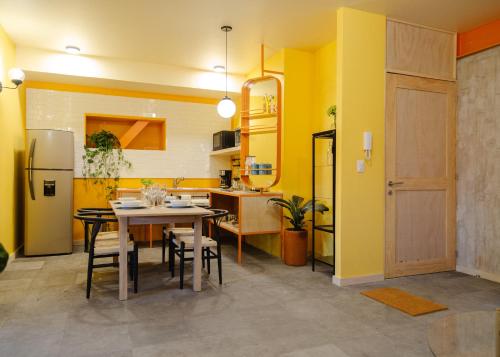 a kitchen with yellow walls and a table and chairs at Roma Majestic By Mr W in Mexico City