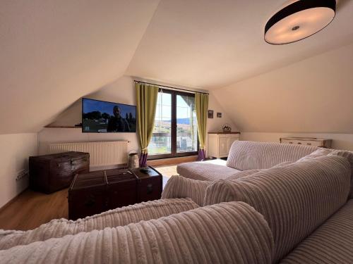 una sala de estar con 2 sofás y una ventana grande en Alpina Lodge Hotel Oberwiesenthal, en Kurort Oberwiesenthal