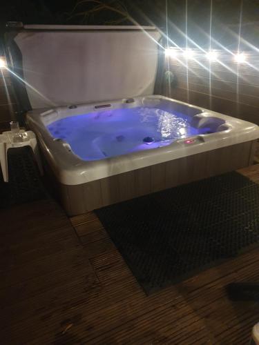 a large blue tub in a bathroom with lights at Chillingham lodge with hot tub Felmoor Park in Felton