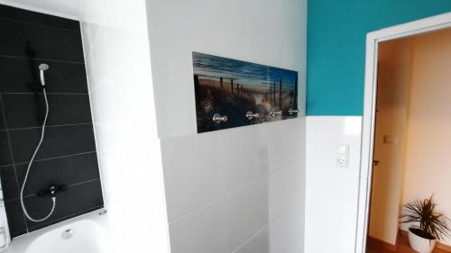 a bathroom with a shower and a painting on the wall at Hedys Apartment in Spiegelsberg