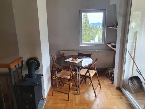 uma pequena mesa e cadeiras num quarto com uma janela em Apartman Huseinbegovic em Vlasic