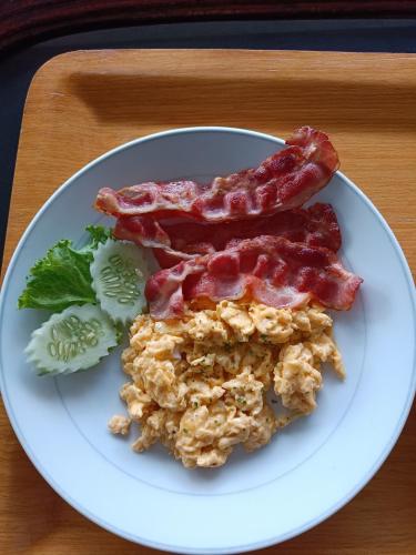 Ban Nam Mao Resort في نا جومتين: طبق من الطعام يحتوي على لحم مقدد وخضراوات على طاولة