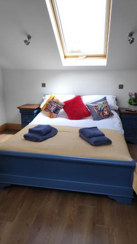 uma cama azul com almofadas num quarto em The Cow Hide @ Mill Burn Hollow. em Millisle