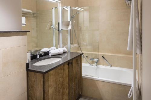 een badkamer met een wastafel en een bad bij La Barrière de Transinne in Libin