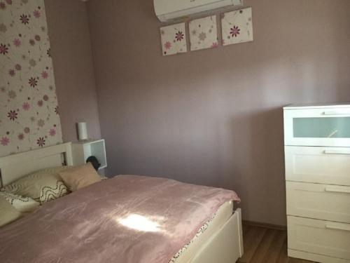 a small bedroom with a bed and a dresser at Kökszi Beach Nyaralóházak in Balatonszabadi