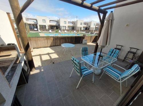 a patio with chairs and a table and an umbrella at Hermosa casa en Bahía inglesa 3 habitaciones in Bahia Inglesa