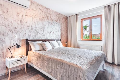 a bedroom with a large bed and a window at Apartment Zagreb Deluxe in Zagreb