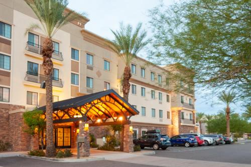 a hotel with palm trees in front of a building at Staybridge Suites Chandler, an IHG Hotel in Chandler