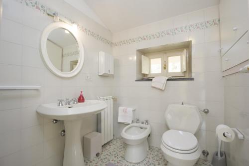 a white bathroom with a toilet and a sink at B&B Il Trebbio in Corsanico-Bargecchia