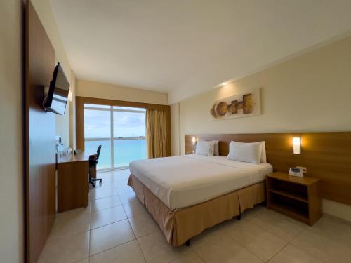 um quarto de hotel com uma cama grande e uma televisão em Praiamar Express Hotel em Natal