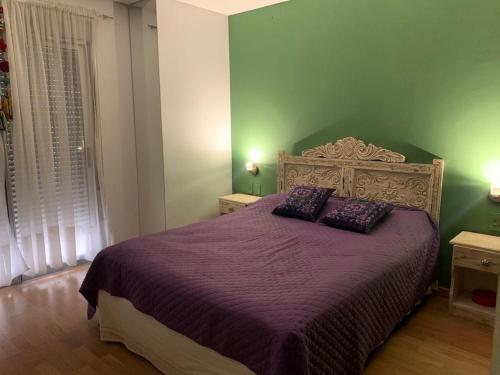 a bedroom with a purple bed with two pillows on it at “Tu Lugar en Santiago” Depto SADIMA - Barrio Centro in Santiago del Estero