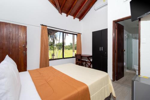 a bedroom with a bed and a large window at Casa Campestre El Danubio in Zaragoza