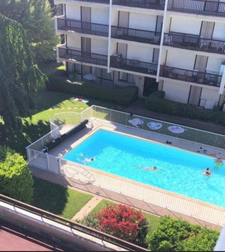 - une vue sur la piscine en face d'un bâtiment dans l'établissement LE COSY avec piscine, balcon et parking, à Trouville-sur-Mer