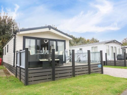 a mobile home with a large window and a fence at 3 Yealands in Carnforth