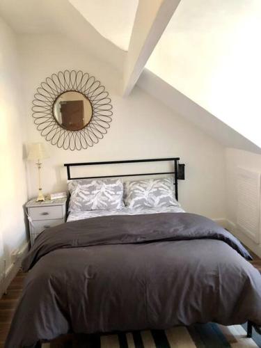a bedroom with a bed with a mirror on the wall at City living maisonette, The Nest in Swansea