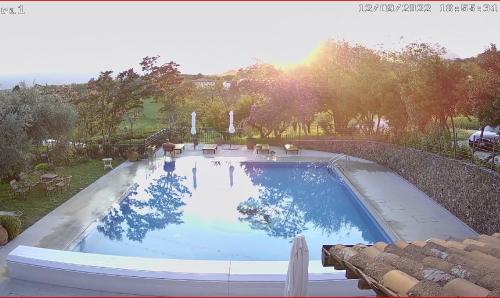 a large swimming pool in a yard with the sun setting at Casa Tonello Zugliano in Zugliano
