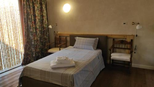 a bedroom with a bed with two towels on it at Casa Tonello Zugliano in Zugliano