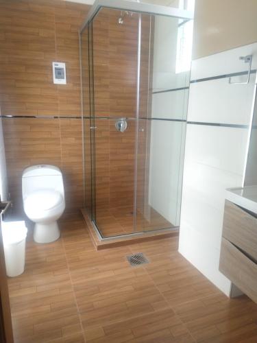 a bathroom with a toilet and a glass shower at Hostal Alvasar in Copacabana