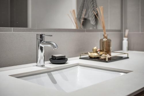 a bathroom sink with a faucet on a counter at Amazing luxury apartment on the waterfront! 73sqm in Oslo