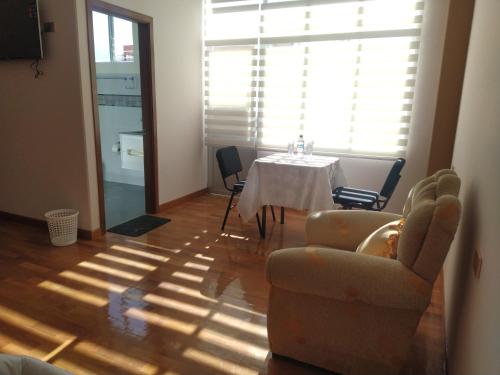 a living room with a table and chairs and a window at Hostal Alvasar in Copacabana