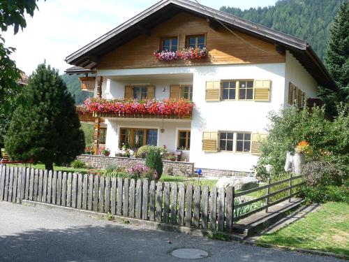 a house with flower boxes on the front of it at Haus am Park in Rasùn di Sotto