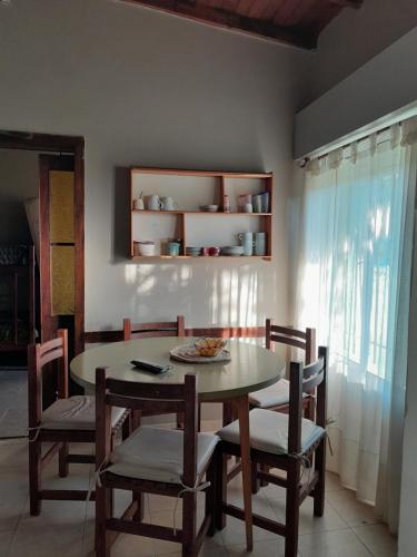 Casa en Necochea في نيكوتشيا: غرفة طعام مع طاولة وكراسي ونافذة