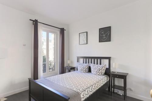 - une chambre avec un lit, 2 tables et une fenêtre dans l'établissement Champs de Mars Appartement, à Paris