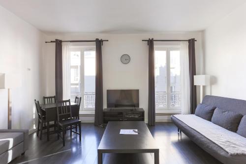 un salon avec un canapé et une table dans l'établissement Champs de Mars Appartement, à Paris