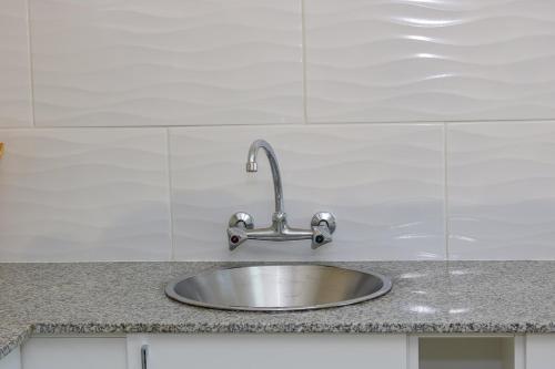 a stainless steel sink in a kitchen with white tiles at 10South in Durban