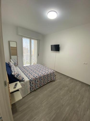 um quarto com uma cama e uma televisão em La Perla Marina em Arma di Taggia