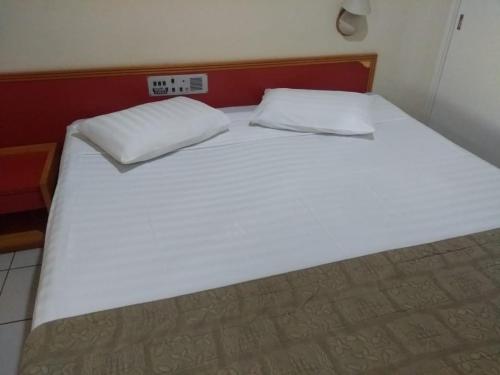 1 cama blanca grande con 2 almohadas en Ocean Tower Fortaleza, en Fortaleza