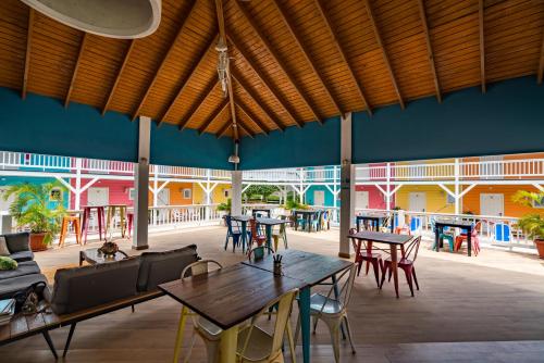 Habitación grande con mesas, sillas y paredes azules. en Bed & Bike Curacao - Jan Thiel en Willemstad