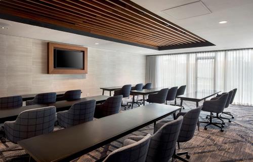 a conference room with tables and chairs and a tv at Marriott Springfield Downtown in Springfield